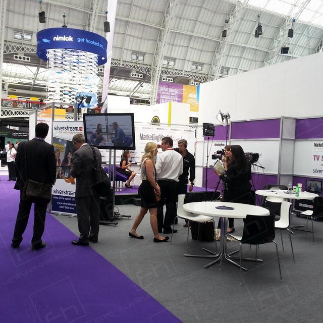 Exhibitions and Furniture Hire UK https://d1hcs5uofxldvl.cloudfront.net/furniture-hire-uk/article_additional/exhibitions1/exhibitions1.jpg - White tabling complements the modern exhibition backdrop.