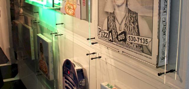 Pizza Exhibition https://d1hcs5uofxldvl.cloudfront.net/furniture-hire-uk/article_additional/pizza-exhibition4/pizza-exhibition4-740x350.jpg - A collection of decorated pizza boxes.