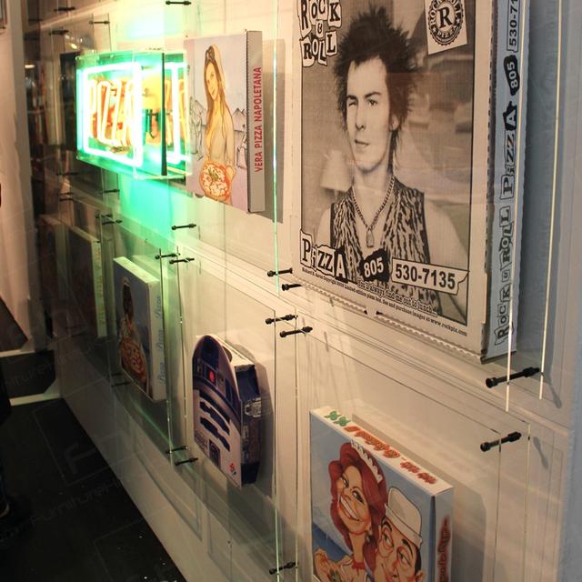Pizza Exhibition https://d1hcs5uofxldvl.cloudfront.net/furniture-hire-uk/article_additional/pizza-exhibition4/pizza-exhibition4.jpg - A collection of decorated pizza boxes.