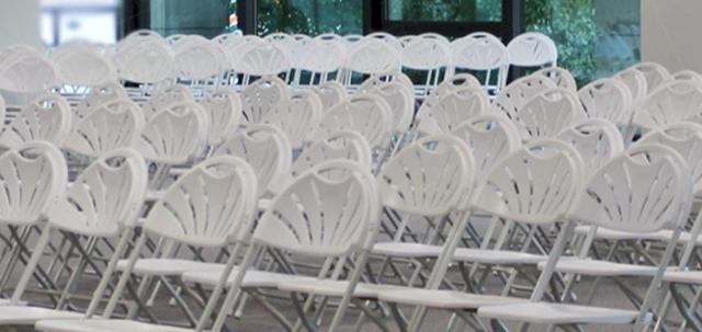 Careers Day Event https://mill-media.s3.eu-west-2.amazonaws.com/furniture-hire-uk/article_additional/bracknell-forest-council1/bracknell-forest-council1-740x350.jpg - White folding chairs set up in simple rows for a large meeting.