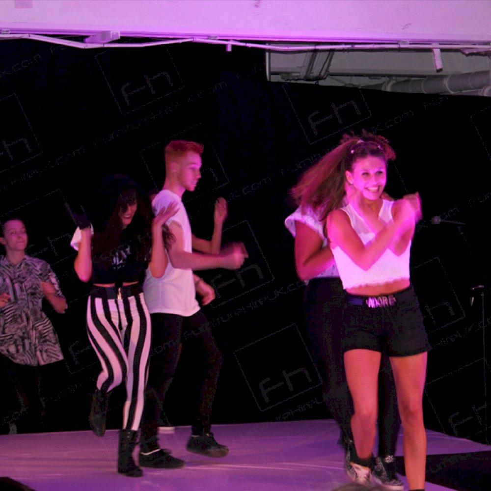 Dancers perform on stage.